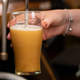 Woman pours pint of beer in pub